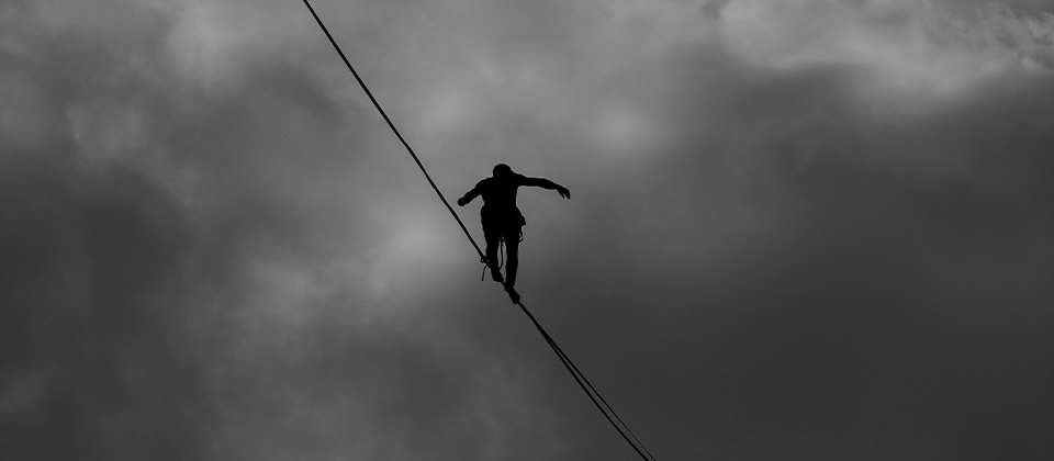 a tightrope walker on a wire, illustrating the concept of risk assessment